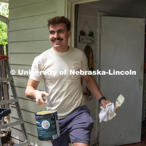 Pi Kappa Alpha’s Cole Gustafson gives a smile after completing the painting of the exterior of a garage during the Big Event. May 4, 2024. Photo by Kirk Rangel for University Communication.